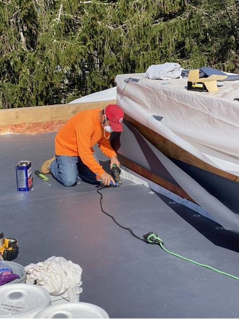 PhotHamish Murrary Construction Inc worker installing roof membrane.