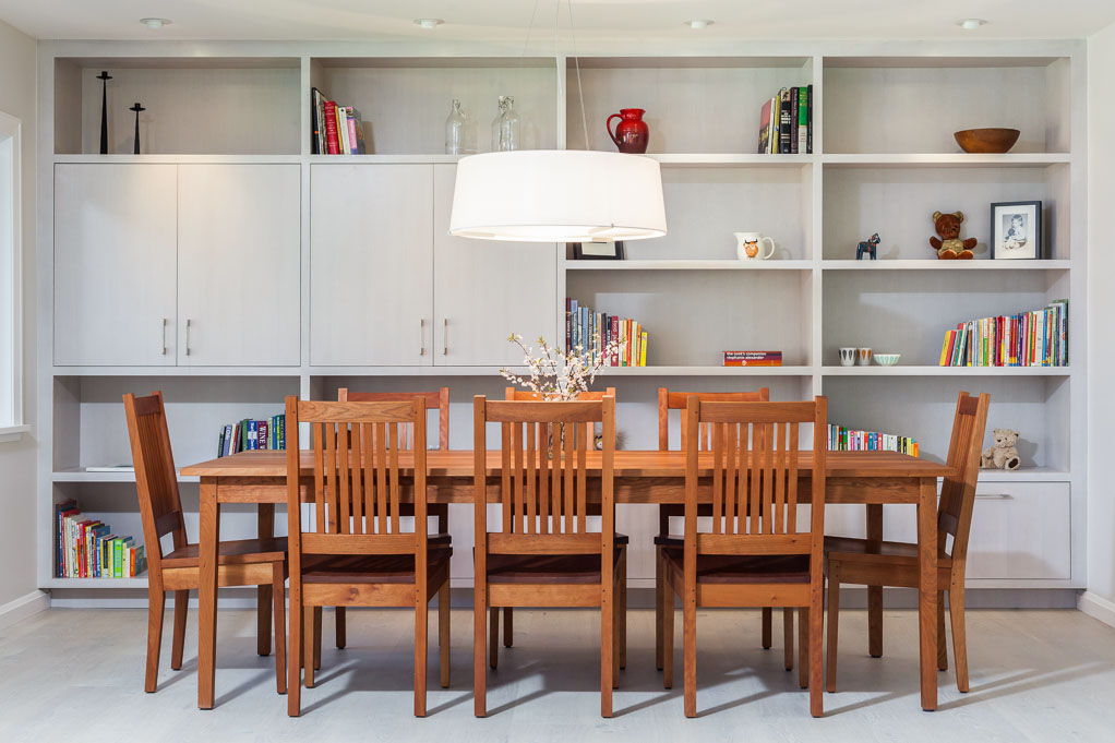 dining room with full wall built-in shelving with cabinetry and full wooden table 