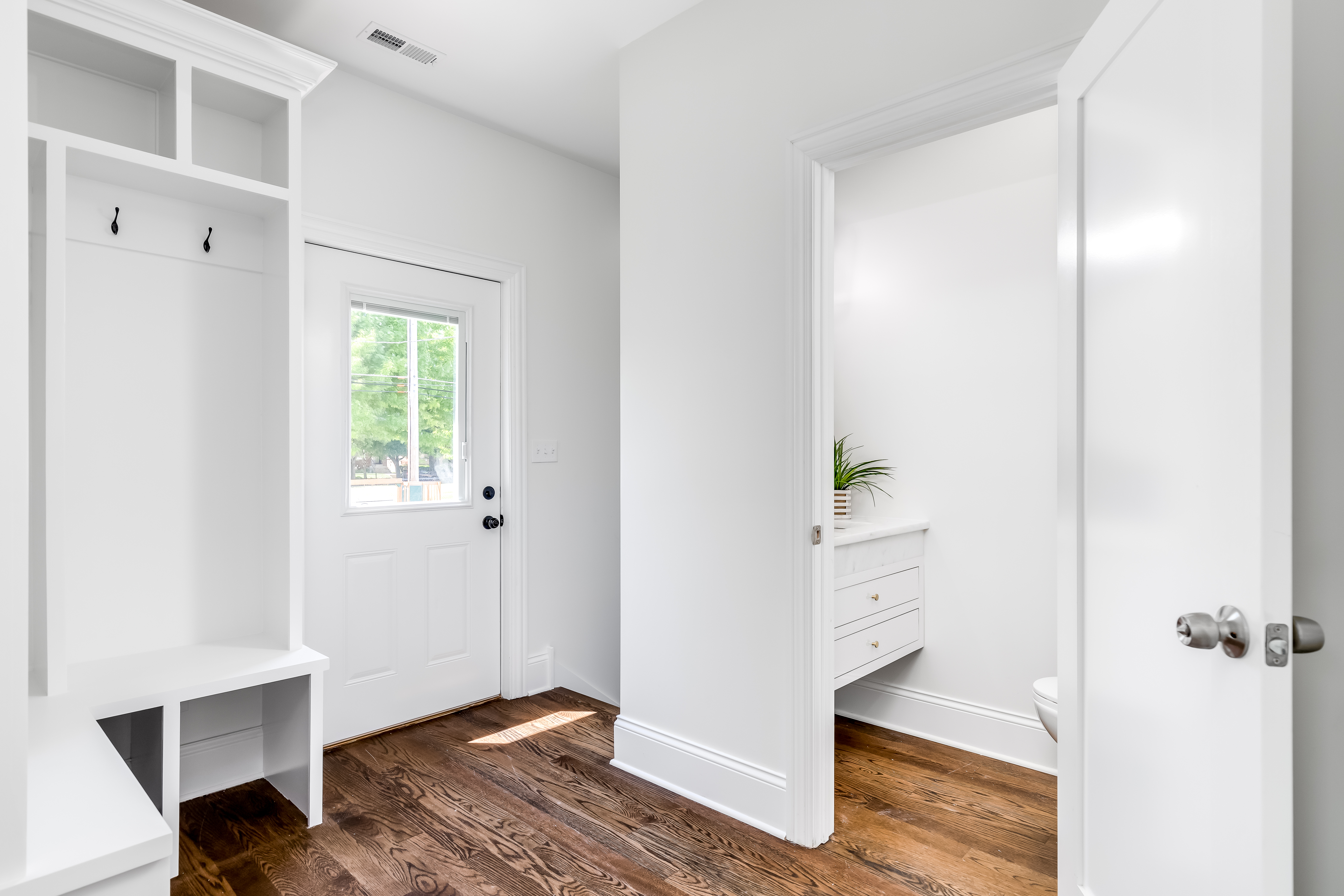 a home with a new, modern, white mudroom