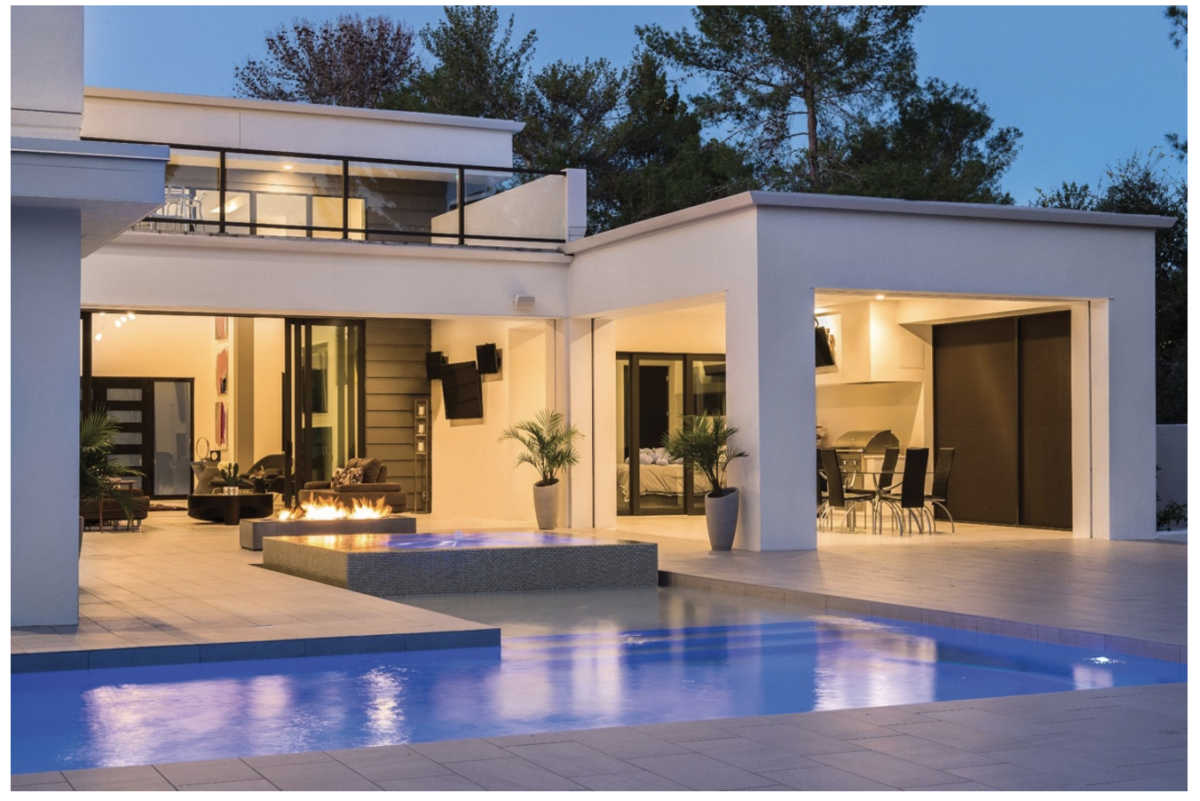 Modern home patio with pool fire pit and outdoor seating with warm ambient smart lighting
