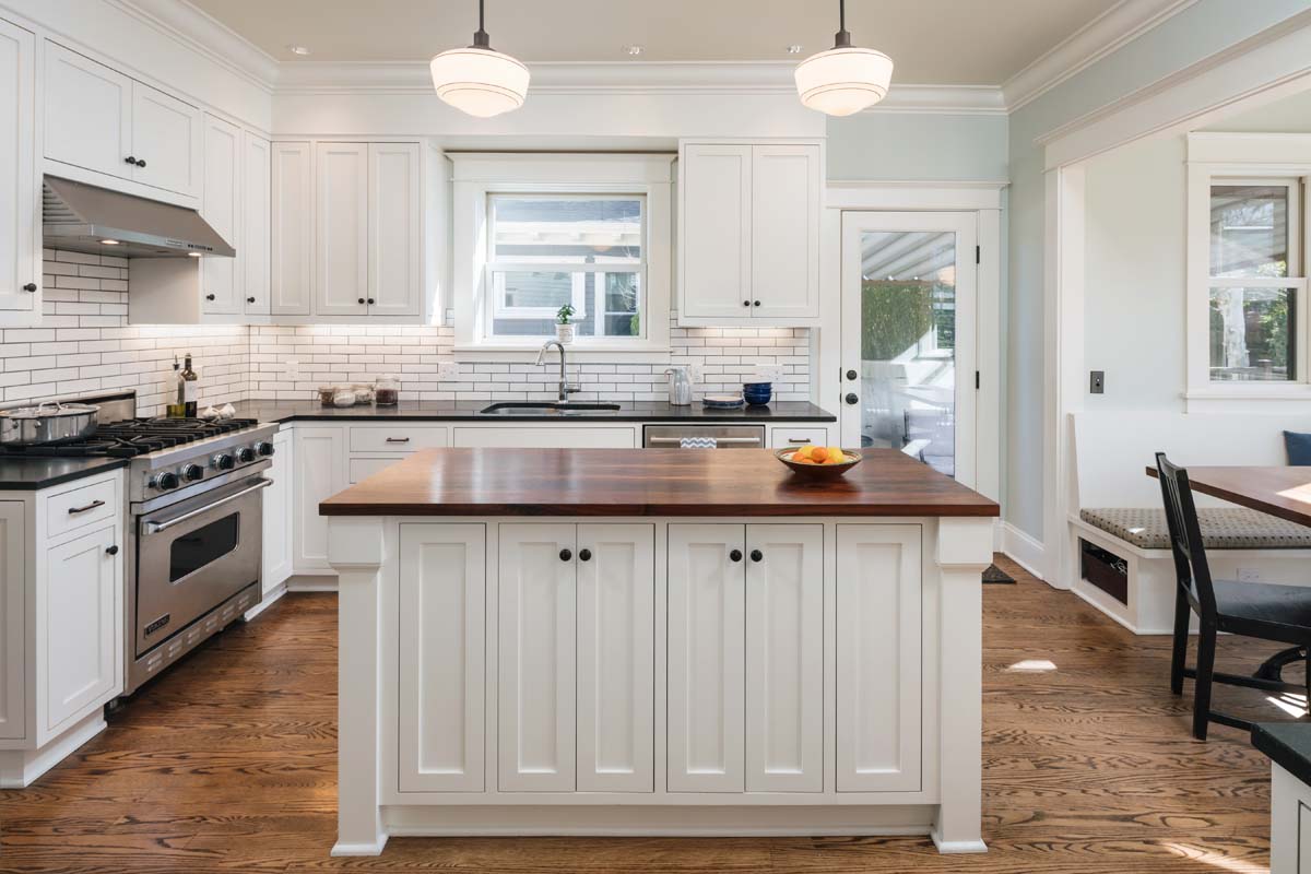 renovated kitchen with large white kitchen island and bright ceiling lights