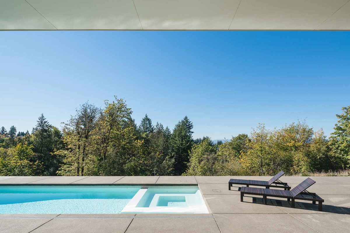 luxurious pool with a beautiful view of the green outdoors