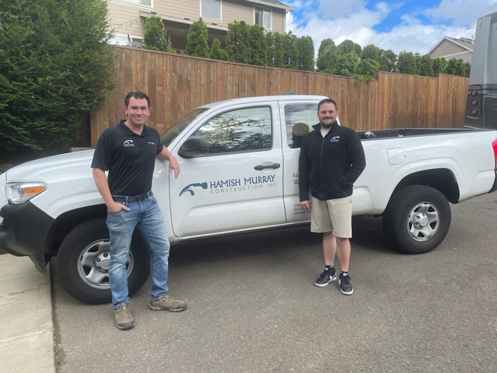 hamish murray construction's project managers, michael and jason standing in front of their company truck